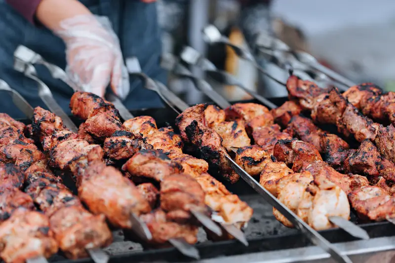 Skewers of peppered meat over the grill